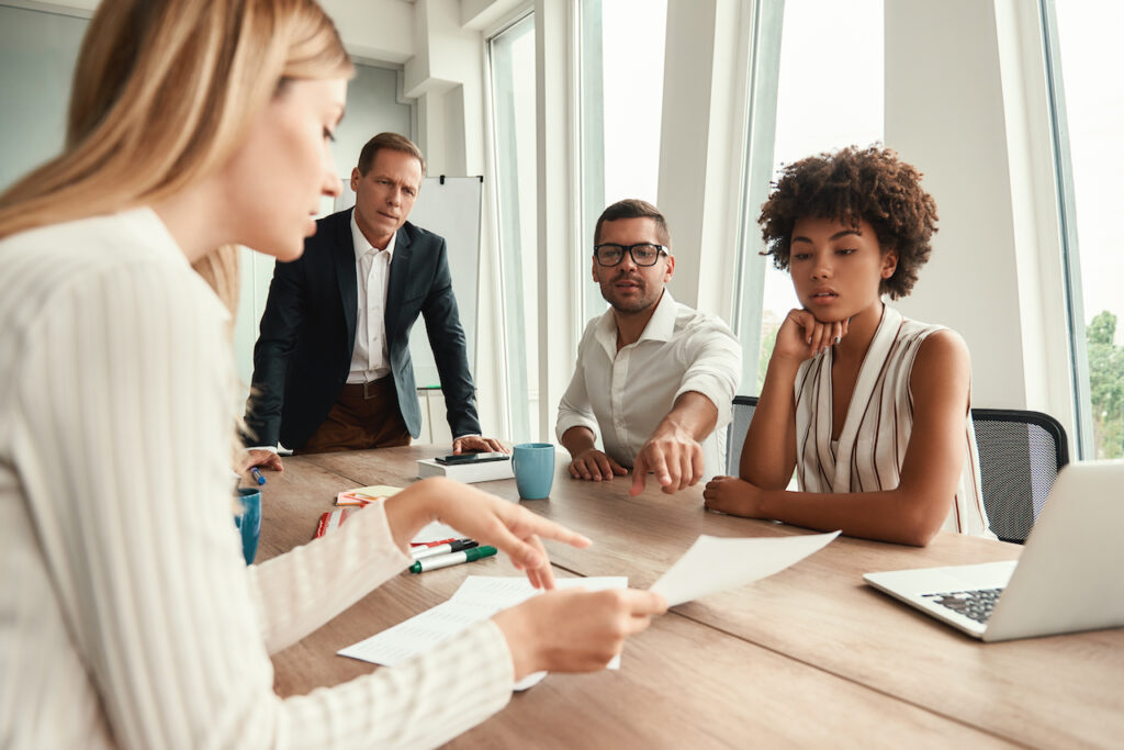 coworkers in meeting discussing business improvement strategies