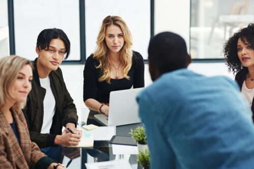 group of coworkers in meeting covering business coaching